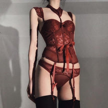 Lady in lace lingerie set featuring a rich burgundy lace longline corset with attached garter straps and a tied bow at the waist