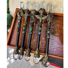 A selection of ornate crystal wands with dark handles, decorative motifs and oval accents