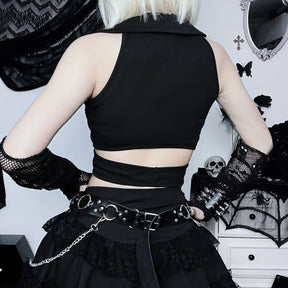 Back view of the black crop top with a solid upper panel and a lower waist band separated by an open horizontal cutout.