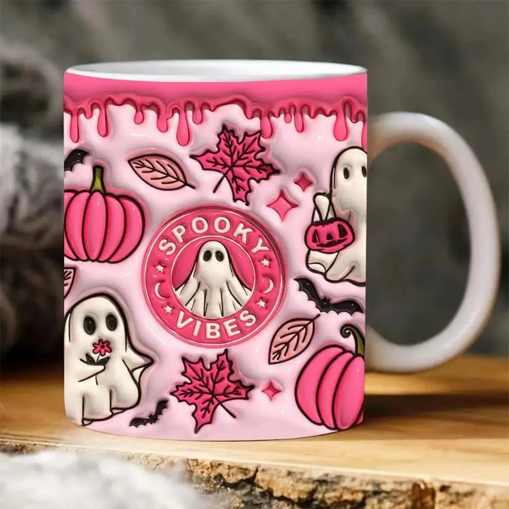 Pink Spooky Vibes mug shown on wood, with a white handle and printed ghosts, pumpkins and leaves.