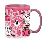 Pink Halloween mug with Spooky Vibes lettering, white ghosts, pumpkins and a pink handle against a white background.