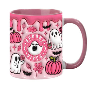 Pink Halloween mug with Spooky Vibes lettering, white ghosts, pumpkins and a pink handle against a white background.