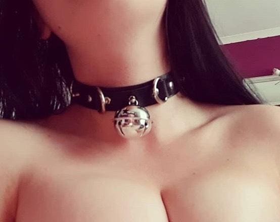 Black faux leather bell collar with silver metal hardware and a dangling bell pendant for cats