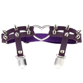 Purple thigh garter shown on white with silver-tone cone spikes across the twin front straps, a heart ring and two stocking clips.