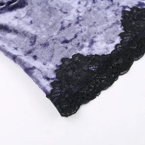 Angled detail of the lower purple velvet panel and its wide black floral lace edge.