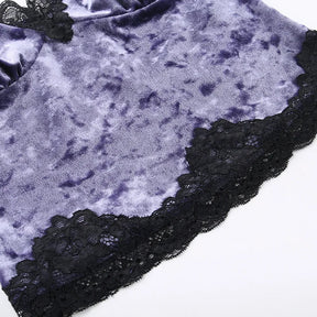 Close-up of black floral lace bordering the purple crushed velvet camisole hem.
