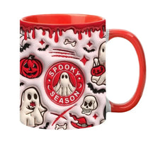 Another view of the red Spooky Season mug with a matching red interior and handle, surrounded by printed ghosts and Halloween motifs.