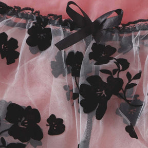 Black ribbon bow at the waist of the sheer floral lingerie briefs.