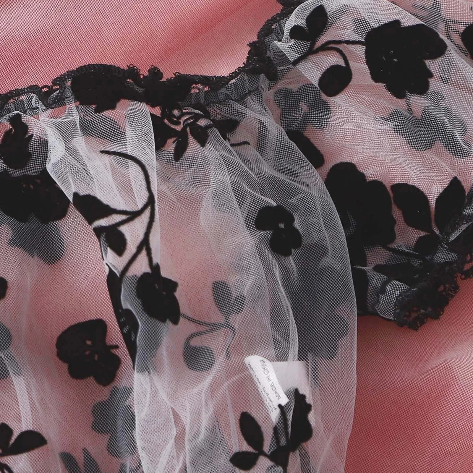 Gathered neckline and black lace edging on the floral off-shoulder lingerie top.