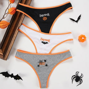 Three Halloween thongs laid flat in black, white and gray, with orange edging and distinct pumpkin, bat and spider motifs.