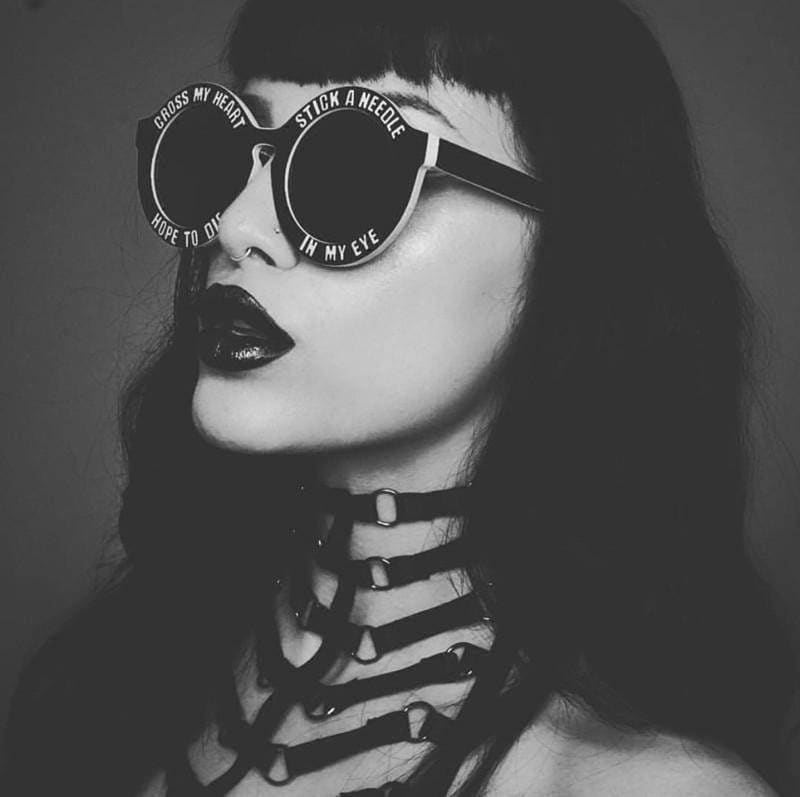 Black round sunglasses with white text around lenses part of ribbed harness collection accessory