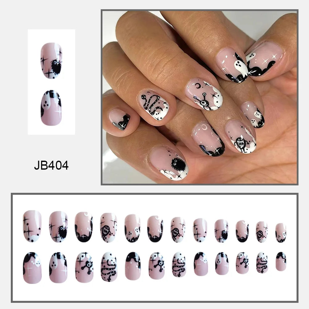 Rounded pink false nails with white ghosts, black edge details and small stars, shown worn above a size assortment.