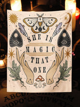 Beige She Is Magic That One tapestry with moth, planchette and botanical artwork displayed in a candlelit corner.