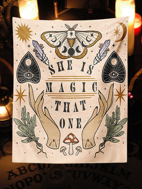 Beige She Is Magic That One tapestry with moth, planchette and botanical artwork displayed in a candlelit corner.