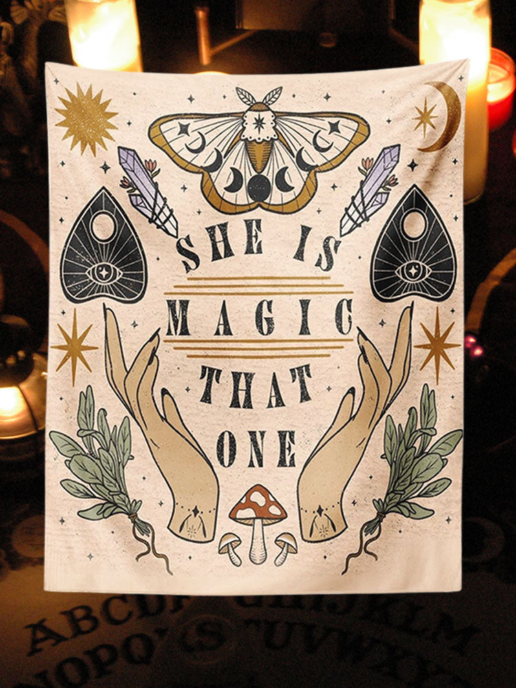 Beige She Is Magic That One tapestry with moth, planchette and botanical artwork displayed in a candlelit corner.