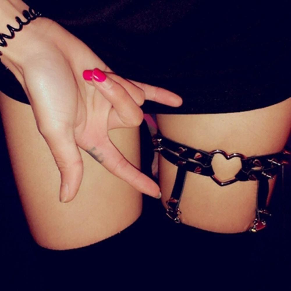 Black leather spiky heart garter belt with heart-shaped metal clasps and red charms for edgy lingerie looks