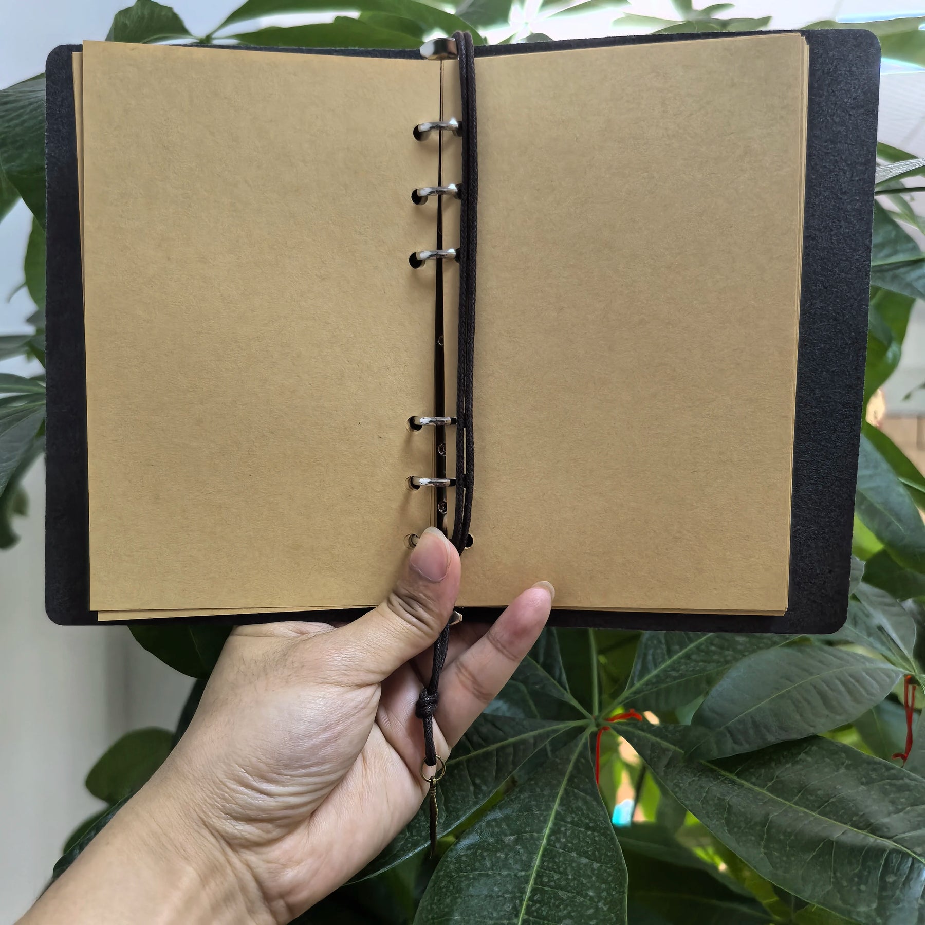Celestial journal opened to plain brown pages, showing the six-ring binder used for arranging and replacing sheets.