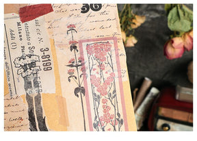 Close-up of a layered journal page with a long pink floral sticker, old handwriting and cream-coloured paper details.
