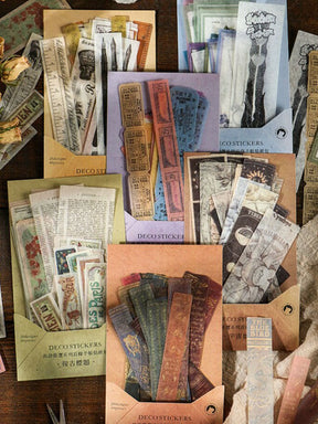 Several packs of long vintage-style stickers arranged together, showing botanical, celestial, ticket and book-spine designs in muted colours.