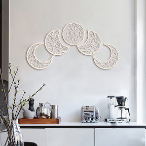 White wooden lunar cutouts displayed in an upward arc over a sideboard, highlighting the ornate scrollwork.