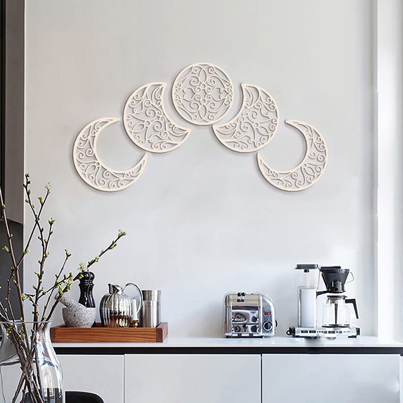 White wooden lunar cutouts displayed in an upward arc over a sideboard, highlighting the ornate scrollwork.