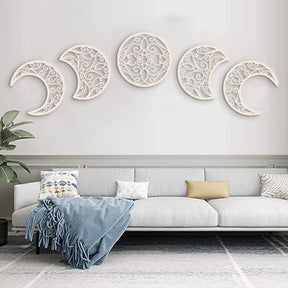 Five white moon-phase cutouts arranged across the wall above a light sofa and blue throw.
