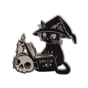 Front of the witch cat spellbook enamel pin isolated on white