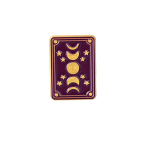 Rectangular purple enamel pin with a vertical sequence of gold-tone moon phases, stars and a fine double border.