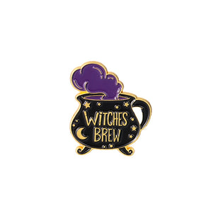 Black Witches Brew cauldron enamel pin with purple steam, small stars, a side handle and gold-tone lettering.