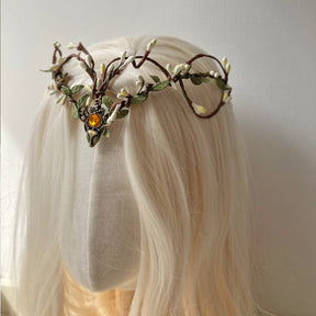Angled view of a pale-bud woodland tiara with looping brown branches and an amber-coloured centre accent.