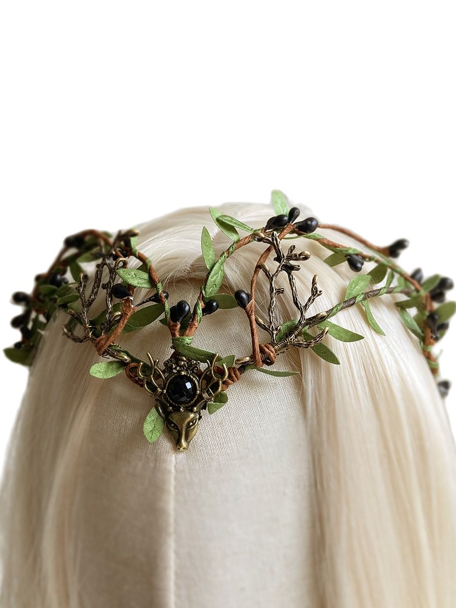 Angled view of a leafy woodland tiara on pale hair, with dark buds, branch-shaped antlers and a black centre accent.