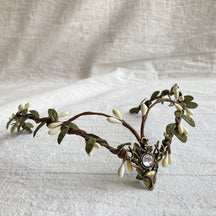 Elf-inspired tiara with brown branching bands, pale buds and leaves around a clear jewel-like deer-head centre.