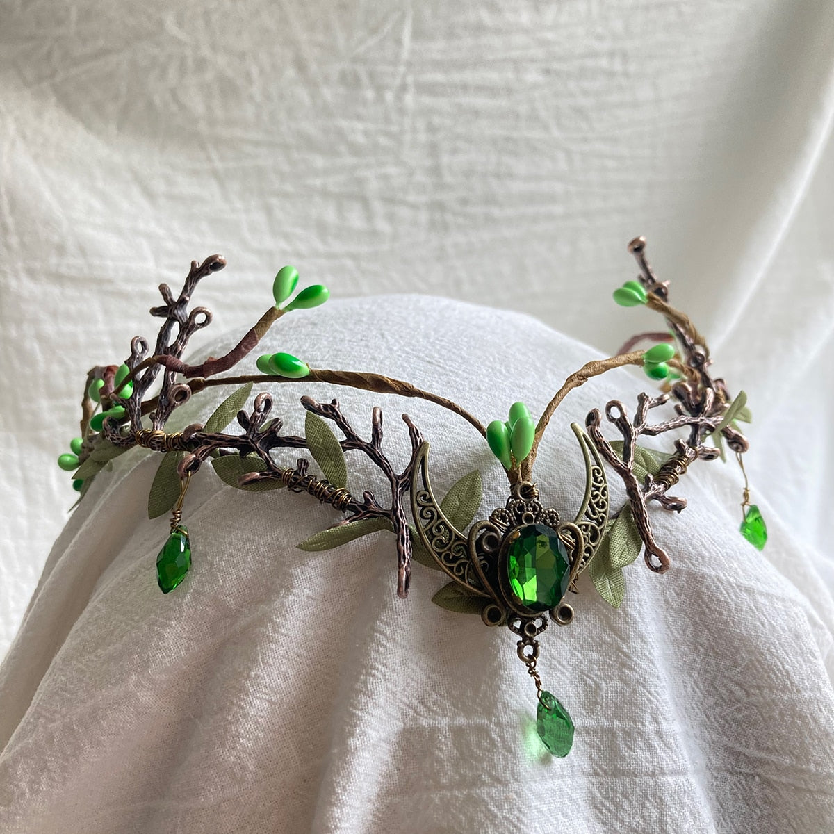Brown woodland tiara with green buds, branching antlers and a dark green oval accent set in a crescent with a hanging drop.