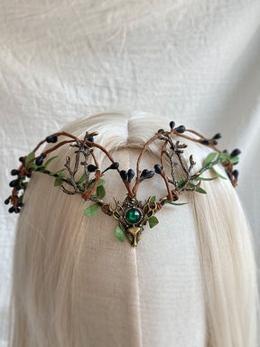 Woodland antler tiara with dark berry-like buds, green leaves and a green centre accent, displayed on pale hair.