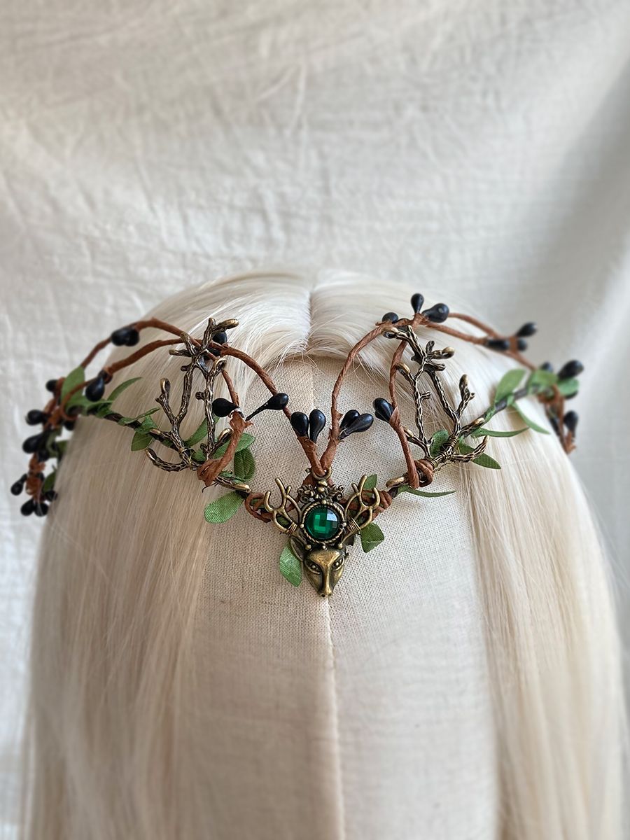 Woodland antler tiara with dark berry-like buds, green leaves and a green centre accent, displayed on pale hair.