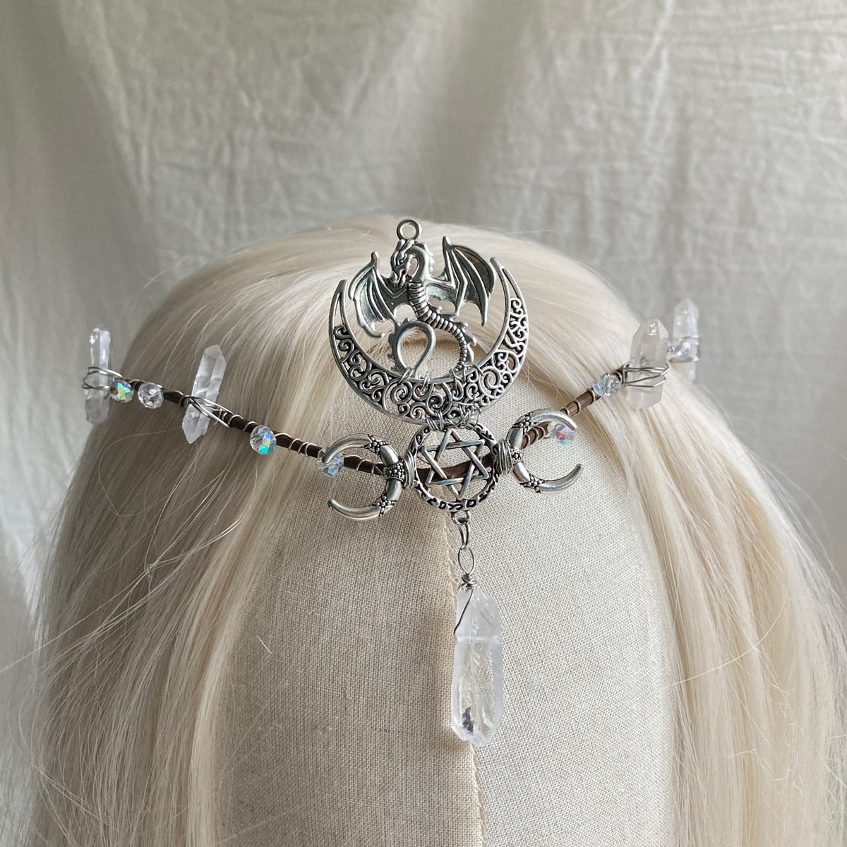 Silver-tone headpiece with a bat and crescent above a pentagram-and-moon band, finished with a long clear hanging point.