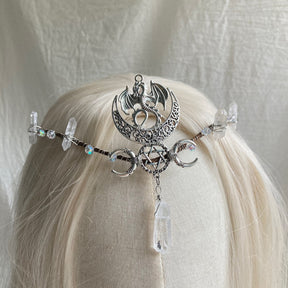 Silver-tone headpiece with a bat and crescent above a pentagram-and-moon band, finished with a long clear hanging point.