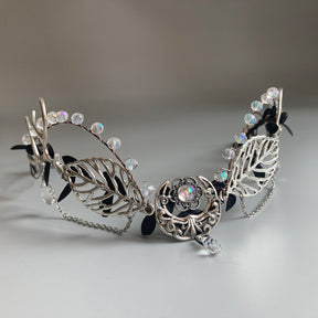 Silver-tone leaf tiara with clear faceted beads, draped chains and a central crescent ornament with a hanging clear drop.