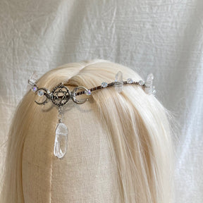 Front view of a slim silver-tone triple-moon and pentagram tiara with clear bead accents and a long central drop.