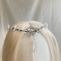 Fine silver-tone tiara with crescent moons flanking a pentagram centre and a long clear point-shaped drop, displayed on pale hair.