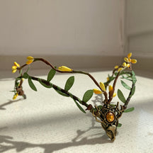 Leafy woodland tiara with yellow buds and an amber-coloured centre accent, photographed in sunlight.