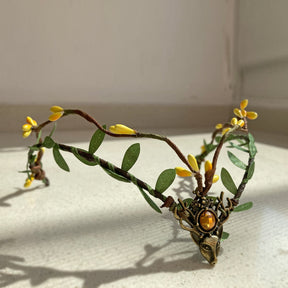 Leafy woodland tiara with yellow buds and an amber-coloured centre accent, photographed in sunlight.