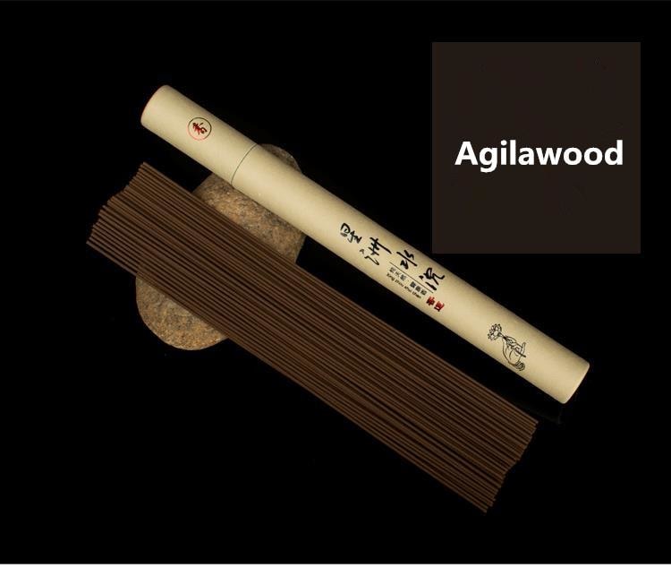 Brown agarwood incense sticks displayed beside a pale paper tube, labelled Agilawood in the image.