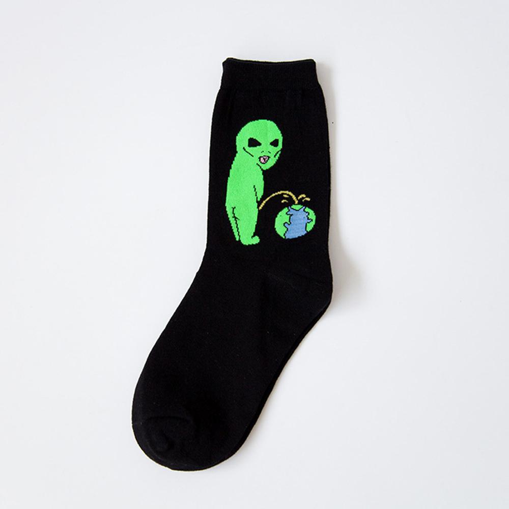 Black sock with a green alien urinating toward a small illustrated Earth, photographed flat on a pale background.