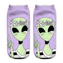 Lavender socks with a smiling green alien wearing a white flower crown and holding up a peace sign.