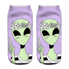 Lavender socks with a smiling green alien wearing a white flower crown and holding up a peace sign.