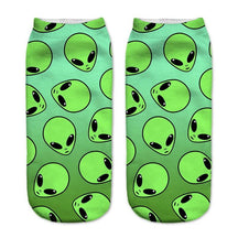 Bright green socks with an all-over pattern of black-eyed alien faces.