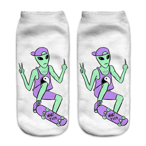 White socks with a green skateboarding alien wearing a purple cap and yin-yang vest. The character makes hand gestures above a board marked What Ever.