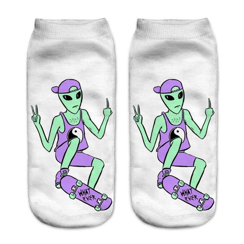 White socks with a green skateboarding alien wearing a purple cap and yin-yang vest. The character makes hand gestures above a board marked What Ever.