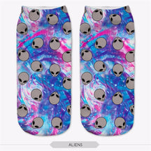 Blue and pink tie-dye-style socks covered in repeated gray alien heads, shown as a pair.